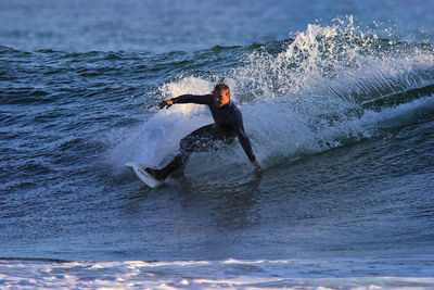 Full length of man splashing water in sea