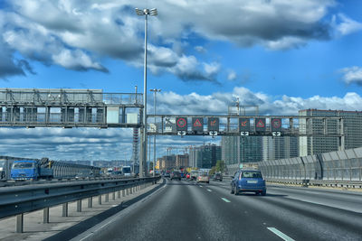 Cars on bridge in city against sky