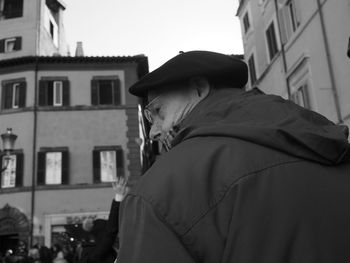 Low angle view of man standing against buildings in city