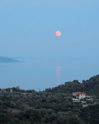 Scenic view of field and buildings against clear sky