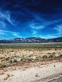 Scenic view of desert against blue sky