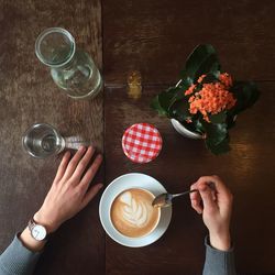 High angle view of person with coffee on table