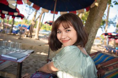 Portrait of smiling young woman sitting outdoors