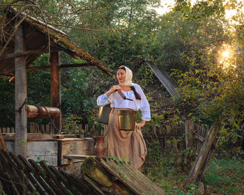 A village young peasant woman is engaged in work in the morning early carries water from the well