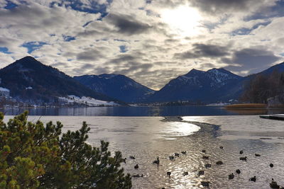 Scenic view of lake by mountains against sky