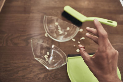 Cropped image of man holding drink on table