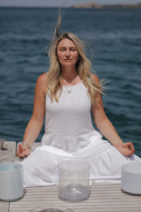 Portrait of young woman using mobile phone in sea