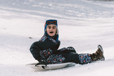 Boy on snow covered field during winter