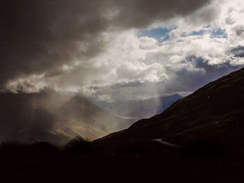 Scenic view of mountains against cloudy sky