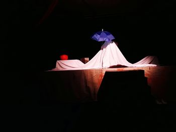 Rear view of woman sitting against black background