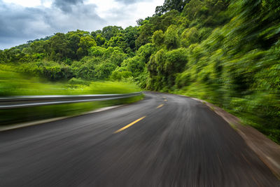 Road amidst trees against sky