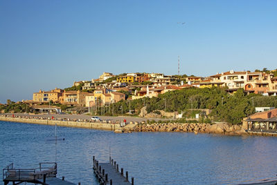 Buildings in city against clear blue sky