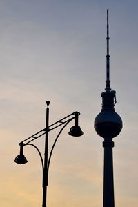 Communications tower against sky during sunset
