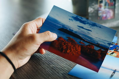 Close-up of hand holding book on table