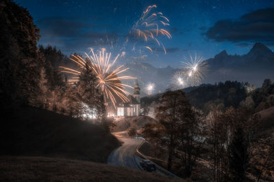 Firework display against sky at night