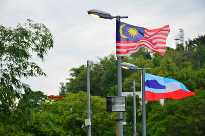 Low angle view of flag flags against sky