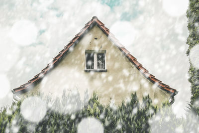 Low angle view of house and trees against sky