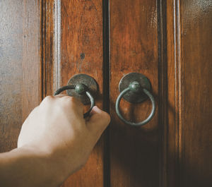 Cropped hand of person holding door knocker