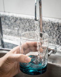 Close-up of hand pouring water in glass