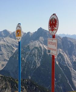 Information sign on mountain against sky