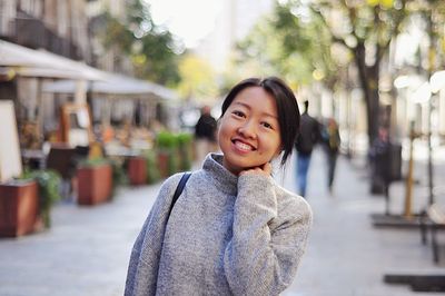 Portrait of a smiling young woman in city