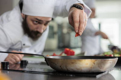 Chef garnishing food in kitchen