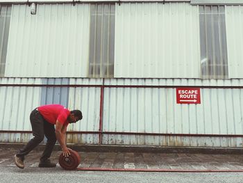 Man folding water pipe on road