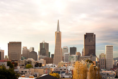 View of skyscrapers against cloudy sky