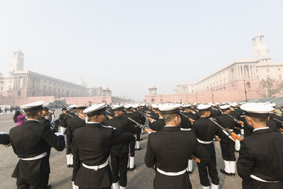 Rear view of people standing against clear sky