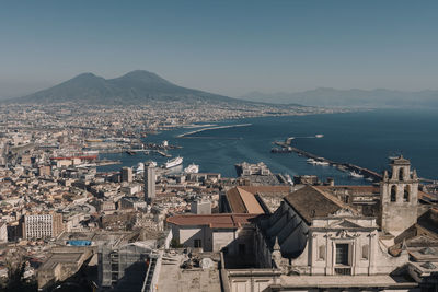 High angle view of townscape by sea against sky