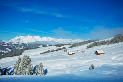 Scenic view of snowcapped mountains against blue sky