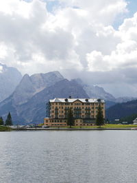 Buildings by lake against sky