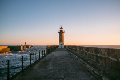 Scenic view of lighthouse on pier at sunset