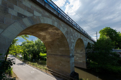 Arch bridge against sky in city