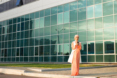 Portrait of woman standing against built structure