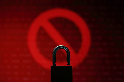 Close up open padlock infront of red no entry sign light and digital binary code