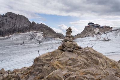 Stack of rock on snow covered land against sky