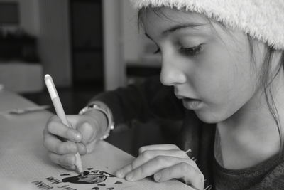 Close-up portrait of young girl holding a pen