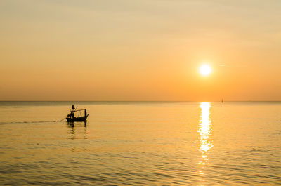 Silhouette boat in sea against sky during sunset