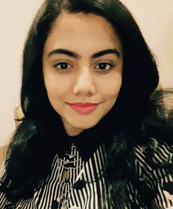 Close-up portrait of smiling young woman at home