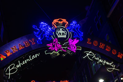 Low angle view of illuminated sign at night