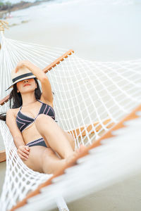 Portrait of young woman sitting in hat