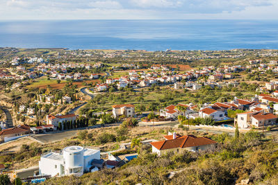 High angle view of townscape by sea against sky