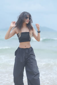 Side view of young woman photographing at beach