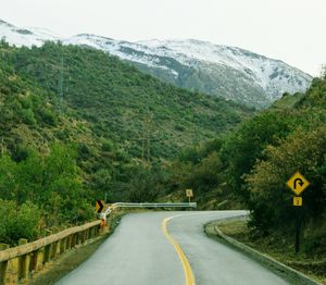 Road by mountains against sky