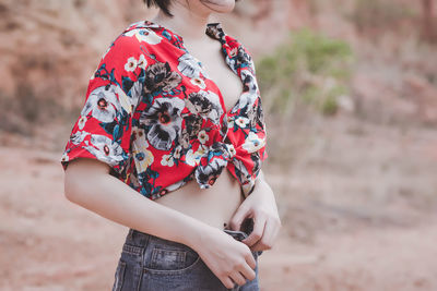 Midsection of woman buttoning jeans