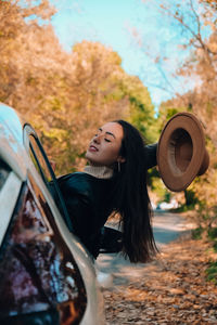 Portrait of young woman with dog on road