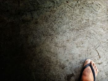 Low section of man standing on concrete floor