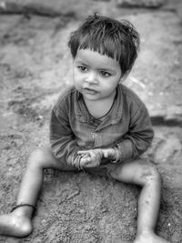 High angle view of girl sitting on field