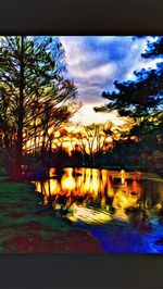 Reflection of trees in water at sunset